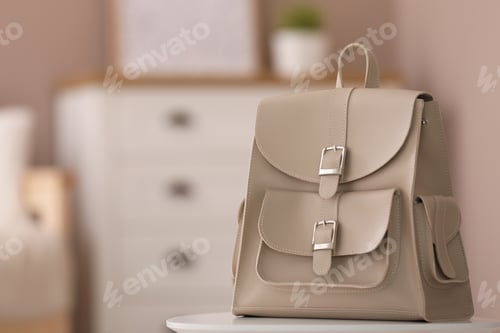 Preview: Stylish beige backpack on white table indoors, space for text
