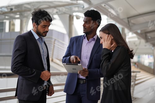 Preview: group of young business people chatting and using laptop at the outside of start up office.
