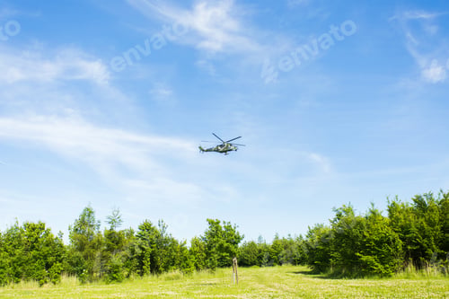Preview: helicopter is flying on blue sky, green ground under it