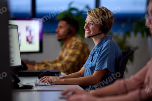 Preview: Business Team Wearing Headsets Working Late At Customer Support Centre