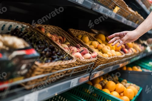 Preview: cropped view of young woman near fruits in supermarket