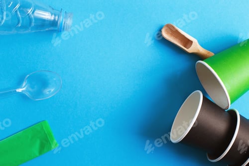 Preview: Eco-friendly disposable tableware made of and paper on a blue background.