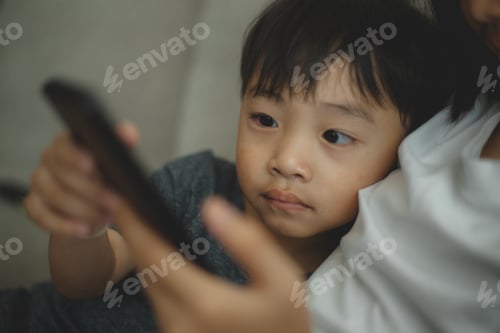 Preview: Child-addicted phone concepts. Asian boy playing smartphone, kid use telephone, watching smartphone.