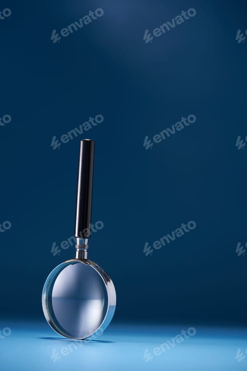 Preview: Closeup of a magnifier against a blue background under the lights