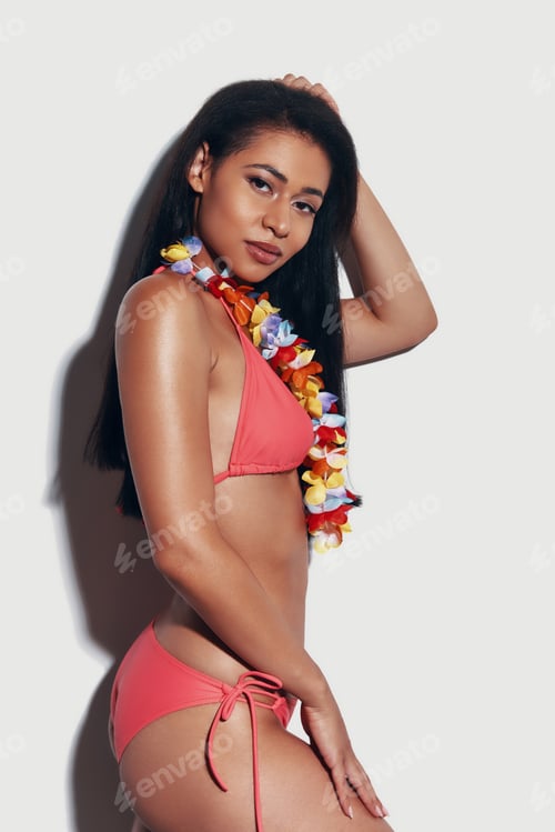 Preview: Attractive young woman in bikini looking at camera and smiling