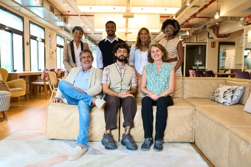 Preview: Diverse business team smiling at modern coworking office