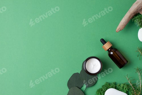 Preview: Cosmetic skin care products with eucalyptus and wood on green background. Flat lay, copy space.