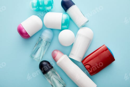Preview: top view of roll on and spray bottles of deodorant on blue background