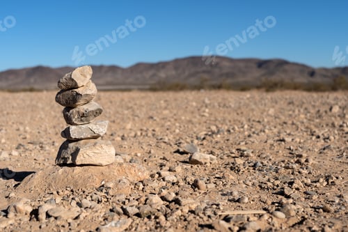 Stacked Rocks in Desert Landscape Under Blue Sky