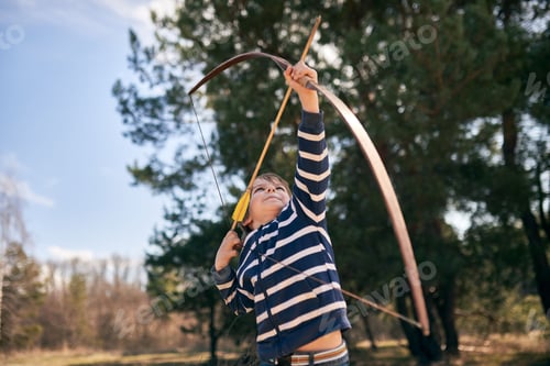 Menino de 6 anos atira um arco ao ar livre