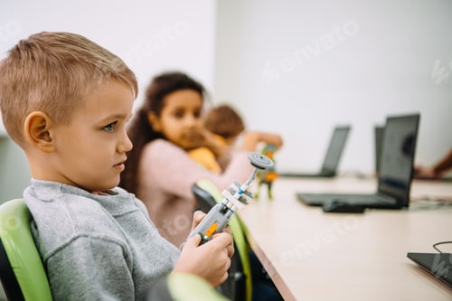 Preview: side view of serious little kid with diy robot