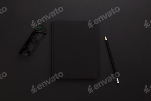 Preview: Top view of low key black office desk with notebook and supplies