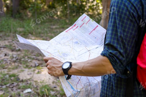 Preview: Young backpacker man looking map while working in trip