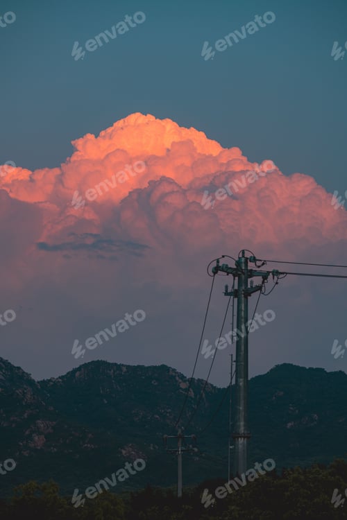 Aperçu: clouds form over mountain range as the sun sets on a cloudy day