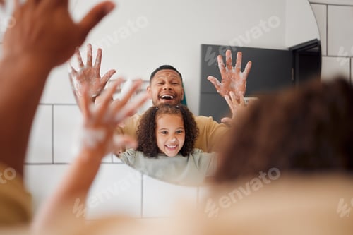 Preview: Happy mixed race father and daughter washing their hands together in a bathroom at home. Single Af