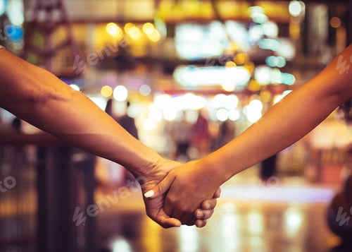 Preview: Cropped image of couple holding hand and walking outdoors in shopping mall
