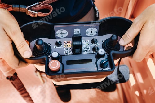 Preview: Remote control of a lifting car crane in the hands of a person. A panel with joysticks and buttons