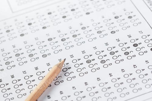 Preview: Multiple choice answer sheet with a pencil resting on it in a study environment