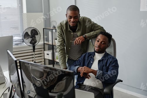 Preview: Two young colleagues discussing working information on computer screen