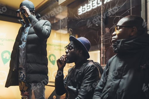 Preview: three young african men waiting on the busstop