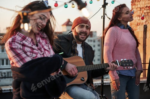Preview: Touching the soul. Three friends enjoy by singing acoustic guitar songs on the rooftop