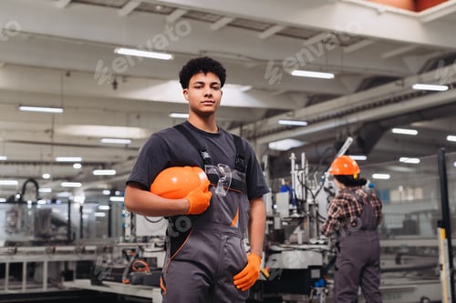 Preview: Young worker standing confident in manufacturing factory
