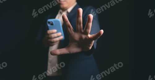 Preview: Man in suit holding phone, gesturing stop with hand