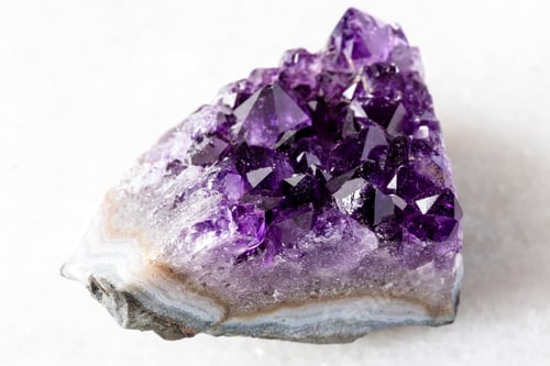 Preview: cut geode of amethyst mineral crystals on white