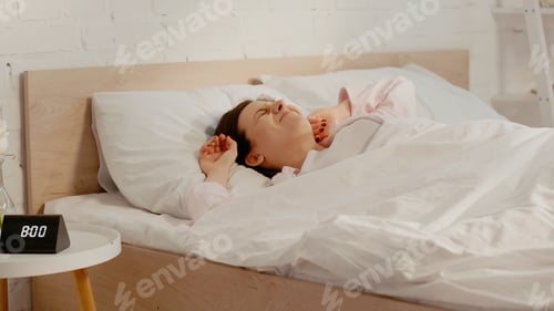 Preview: Sleepy woman lying on bed in morning