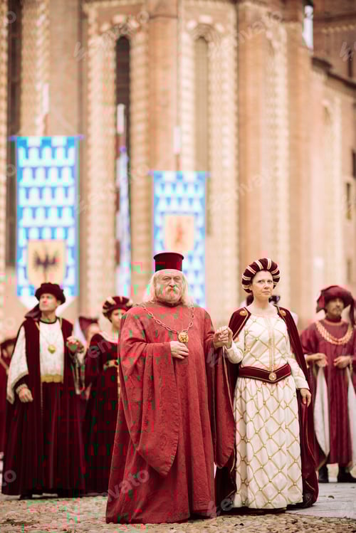 Preview: A regal procession in historical attire outside a medieval building.