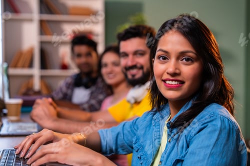 Preview: Completing group assignment happily, Indian college students collaborate in friendly library setting