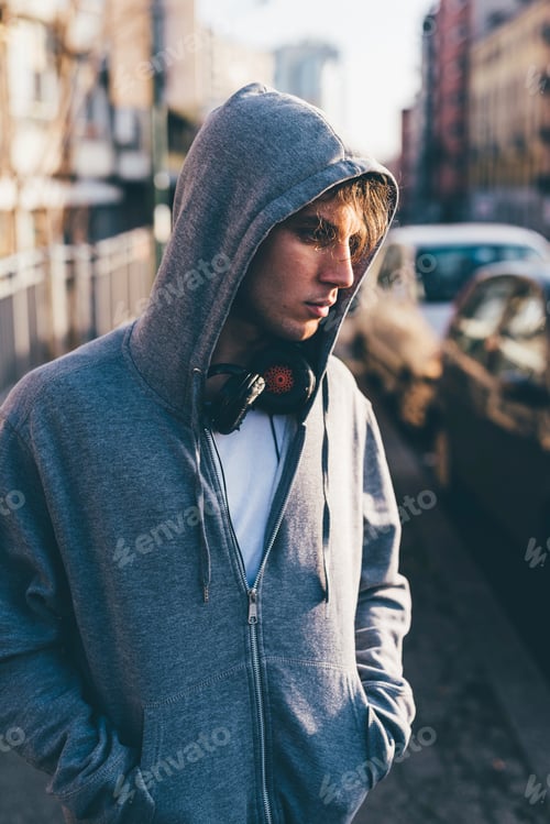 Preview: Young person with headphones in urban setting.