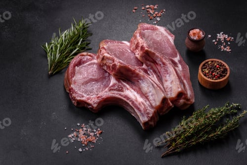 Preview: Fresh raw pork meat on the ribs with spices and herbs on a wooden cutting board