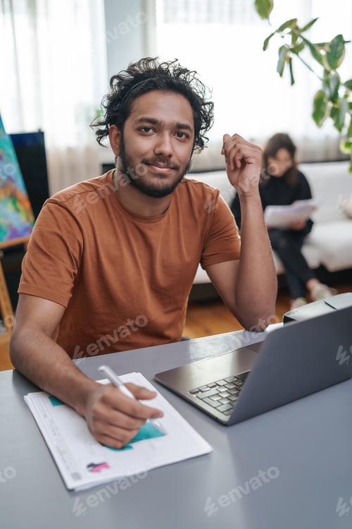 Preview: Portrait of a indian designer doing his work with laptop in office