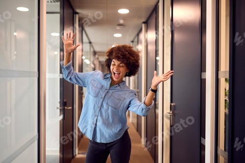 Preview: Happy Young Businesswoman Celebrating Dancing Along Corridor In Modern Office