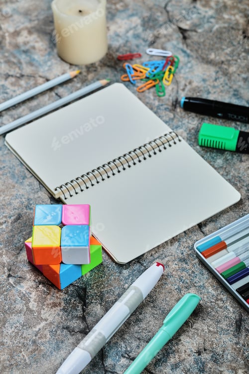 Preview: Empty notebook with pencils, candle, paper clips on the marble background