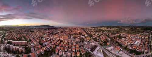 Preview: Panoramic cityscape at sunset with vibrant sky.