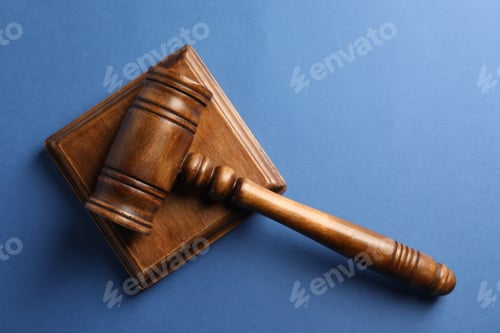 Preview: Wooden gavel and sound block on blue table, top view