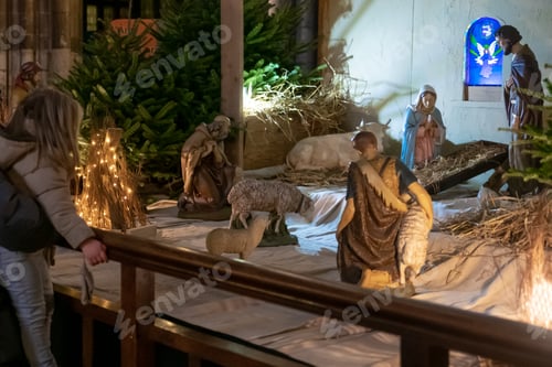 Preview: Father and daughter look at the Christmas nativity scene Creche