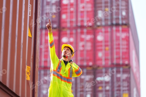 Preview: Worker directing operations at cargo yard during bright afternoon