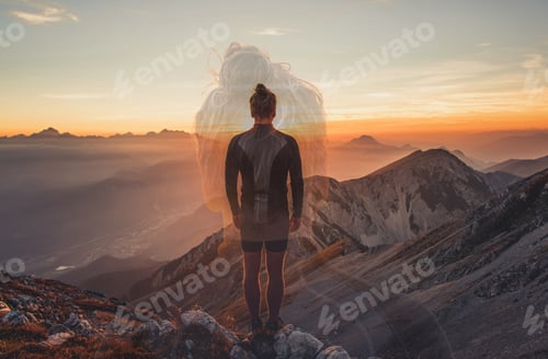 Preview: Male hiker observing the sunset at the top of the local big mountain