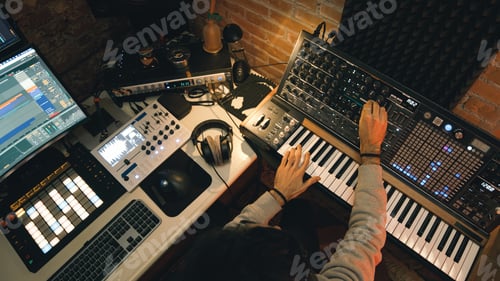 Preview: Man Composing Music with Synthesizer in Recording Studio