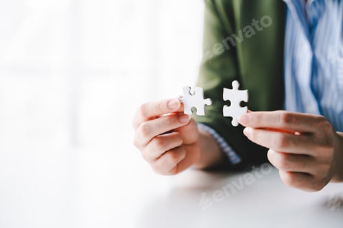 Preview: Close-up of business hands connecting with jigsaw puzzle achievements and goals Business concept, st