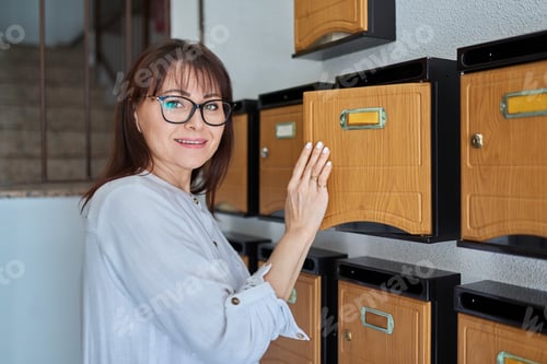 Preview: Woman checking mailboxes inside an apartment building