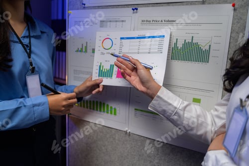 Preview: Professionals discussing financial charts and graphs on a bulletin board