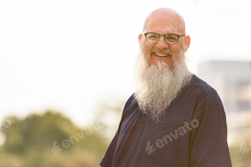 Preview: Portrait of happy mature bald bearded man with eyeglasses smiling