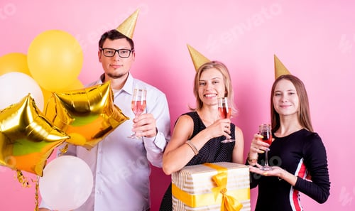 Visualização: Grupo de amigos bebendo vinho comemorando aniversário em fundo rosa
