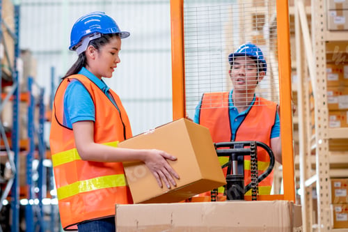 Preview: Warehouse woman or factory worker hold package box in front of hand stacker
