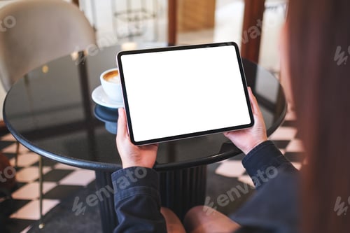 Preview: Mockup image of a woman holding digital tablet with blank white desktop screen in cafe