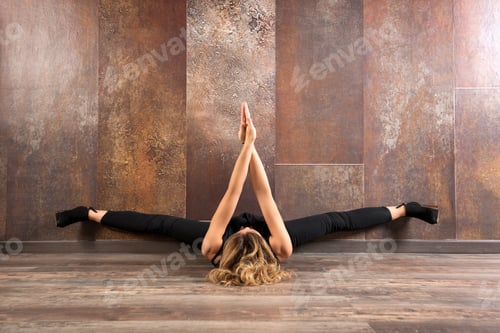 Preview: Fit woman exercising yoga on wooden floor